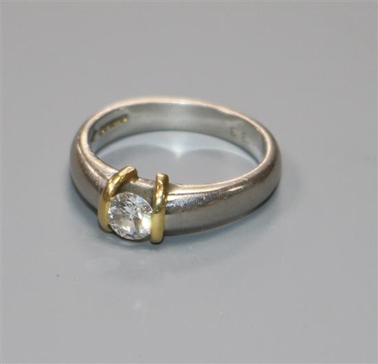 A modern platinum and solitaire diamond ring, in a yellow gold setting, size H.